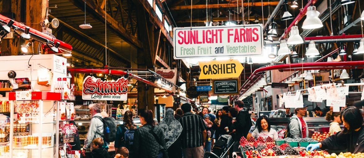 Shoppers browsing produce stalls in a covered market hall